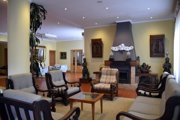 Salón principal con chimenea y sillones del Hotel O Colmo, decorado con esculturas y obras de arte