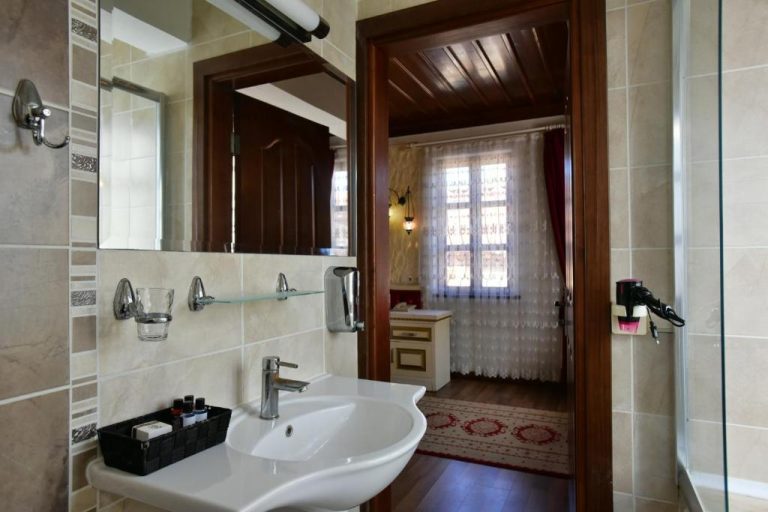 Baño privado moderno con lavabo y espejo grande en el Cicerone Lodge Hotel