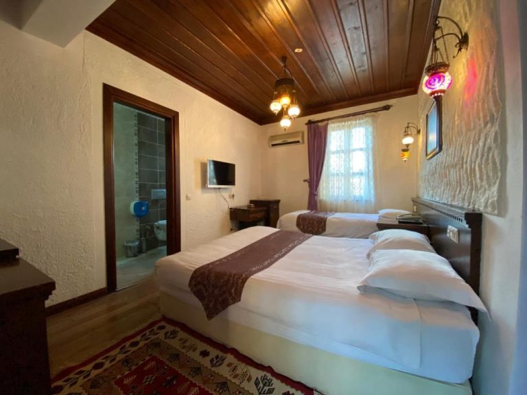 Habitación twin con techo de madera y decoración otomana en Cicerone Lodge Hotel