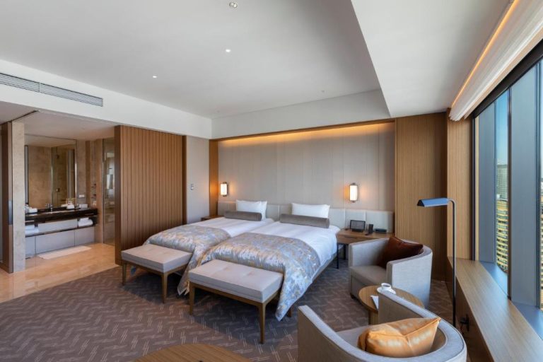 Habitación deluxe con cama doble, zona de estar y vistas panorámicas a Tokio en The Okura Tokyo