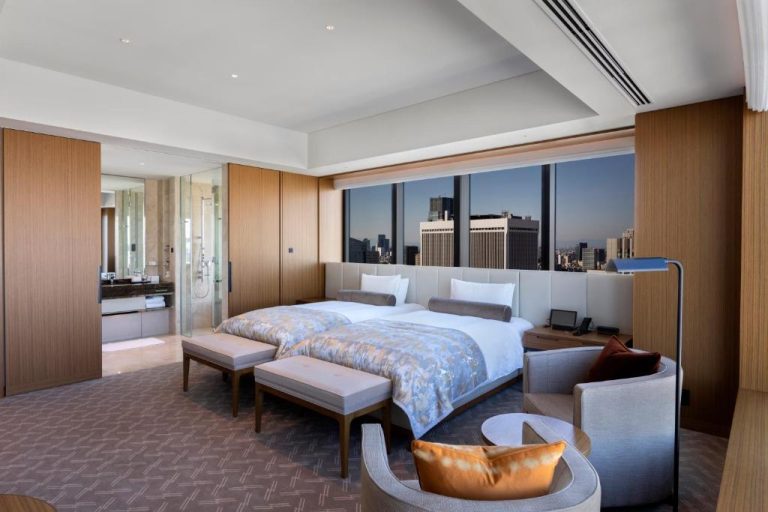 Habitación deluxe con camas twin y vistas panorámicas a los rascacielos de Tokio en The Okura Tokyo