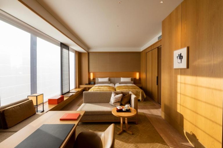 Suite de lujo con zona de estar y camas twin en The Okura Tokyo con decoración japonesa minimalista
