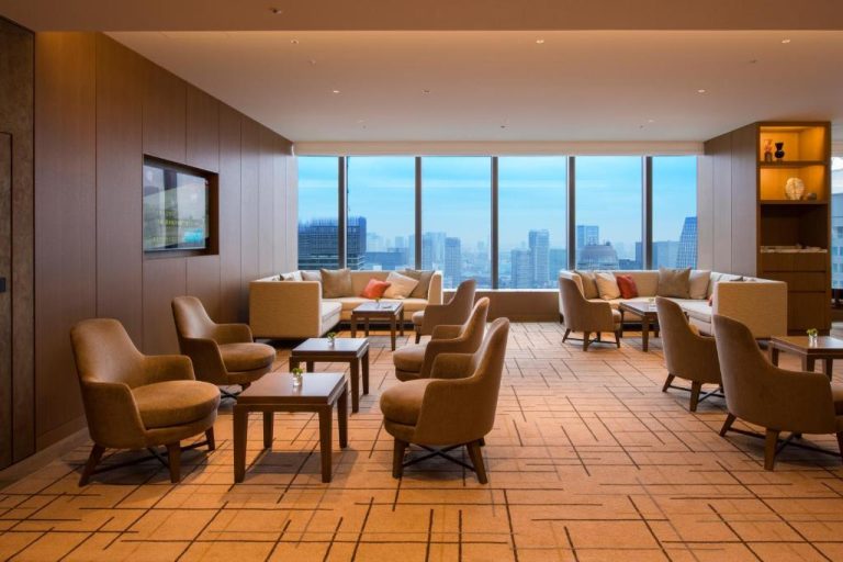 Elegante lounge ejecutivo con sofás y sillones del The Okura Tokyo con vistas panorámicas a la ciudad