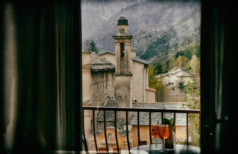 Terraza del Auberge Saint Martin con vistas al campanario histórico y montañas alpinas al fondo
