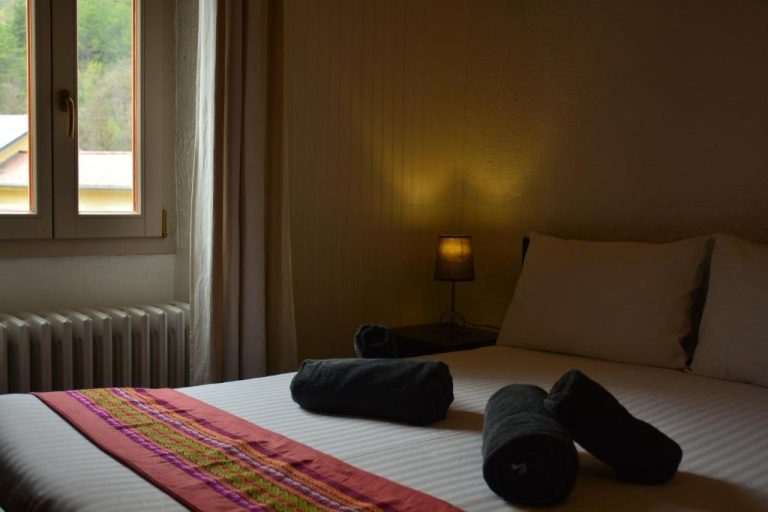 Habitación doble acogedora con toallas enrolladas y lámpara de noche en Auberge Saint Martin