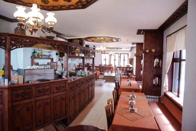 Restaurante interior con barra de madera tallada y mesas del Spa Complex Aleksandar