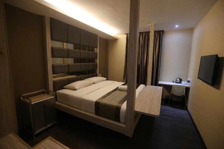 Habitación doble con cama con dosel y escritorio en Kota Heritage Hotel, decoración moderna