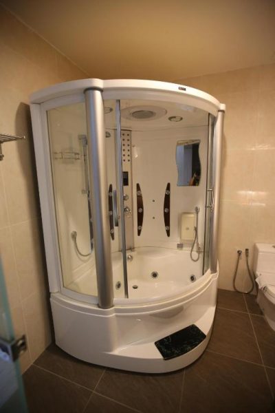Cabina de ducha con hidromasaje y bañera integrada en el baño del Kota Heritage Hotel