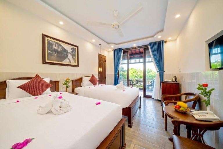 Habitación doble con balcón y decoración floral en Bonsai Villa Hoi An, Vietnam