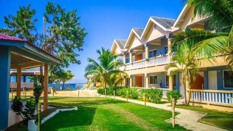 Exterior del Tamboo Resort con jardines tropicales, palmeras y villas frente al mar Caribe