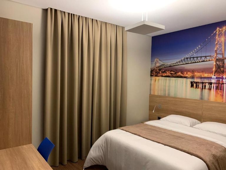 Habitación doble del Hotelog con camas individuales y mural decorativo de puente iluminado
