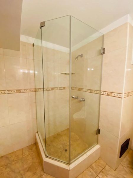 Ducha de cristal esquinera con base de mármol y acabados en cromo del Hotel Continental Lima