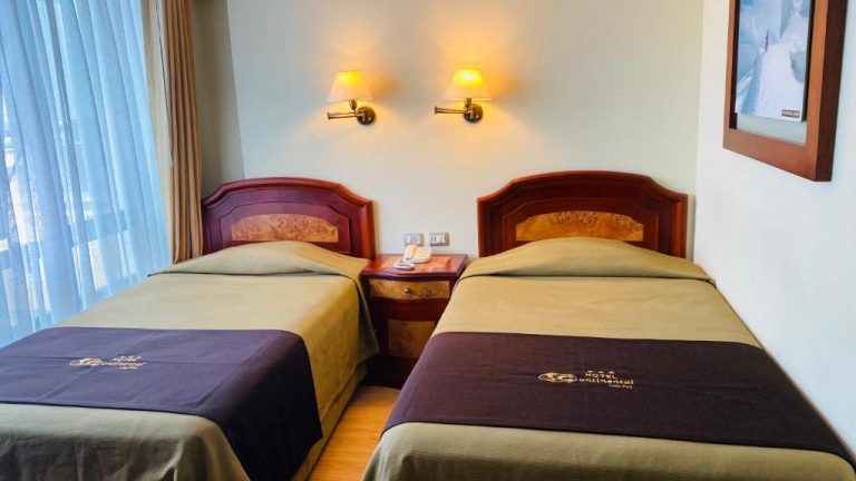 Habitación twin con dos camas individuales y lámparas de pared en Hotel Continental Lima