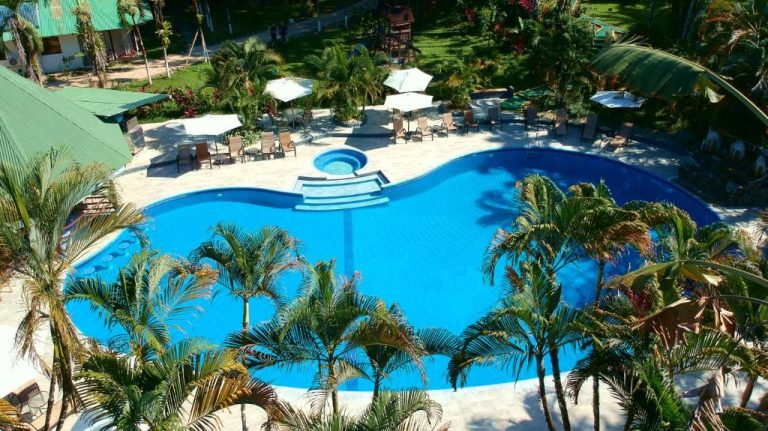 Vista aérea de la piscina exterior con jacuzzi y jardines tropicales del Hotel Villas Rio Mar