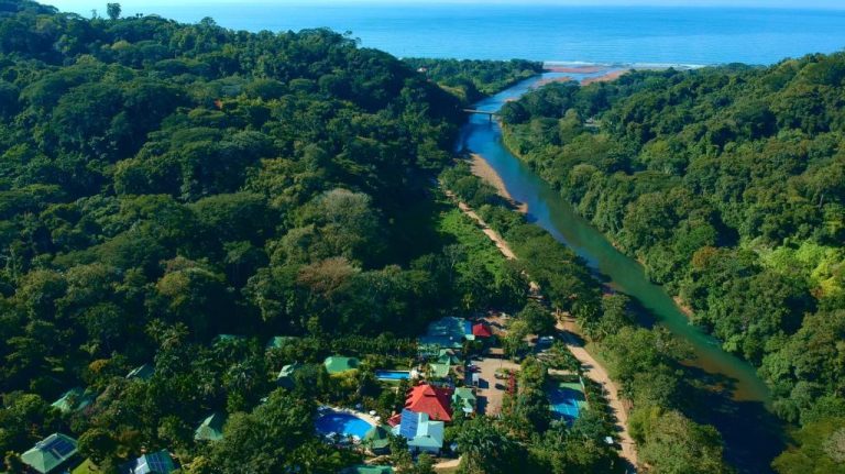 Vista aérea del Hotel Villas Río Mar rodeado de selva tropical con río y acceso al mar en Costa Rica