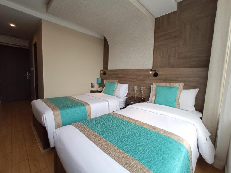 Habitación doble twin con camas individuales y decoración en turquesa del Hotel Diamond Lima