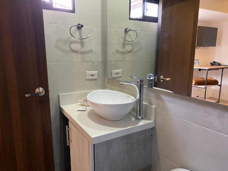 Baño moderno con lavabo sobre encimera y grifo plateado en Rivière Boutique Hotel