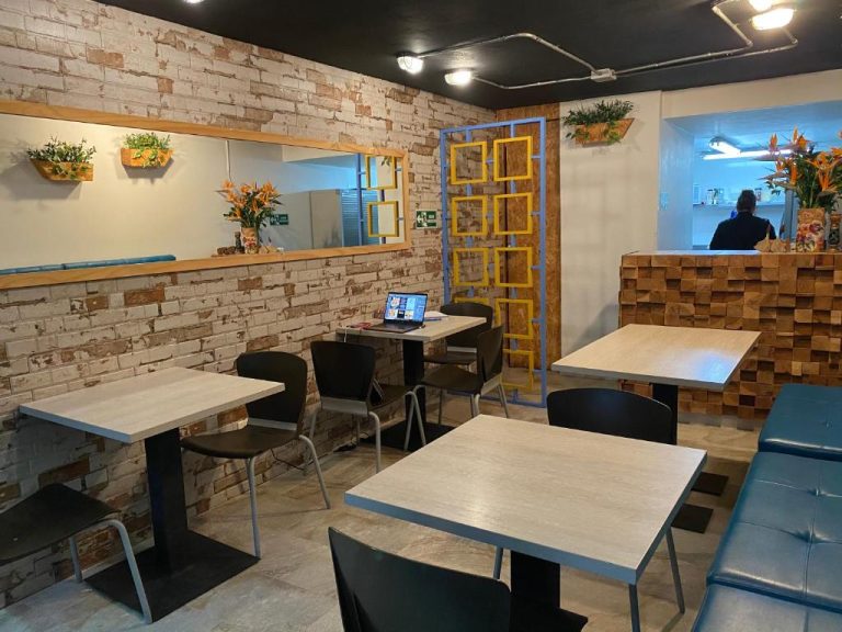 Restaurante interior del Rivière Boutique Hotel con mesas de madera, pared de ladrillo y decoración moderna