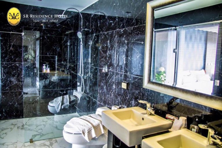 Baño de lujo con mármol negro, ducha de cristal y lavabo del SR Residence Hotel