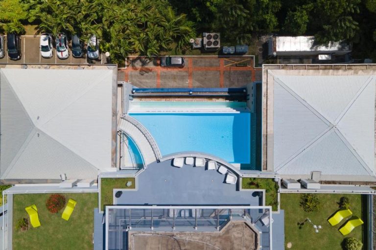 Vista aérea de la piscina exterior y terrazas del Karibea La Valmenière Hôtel con tumbonas
