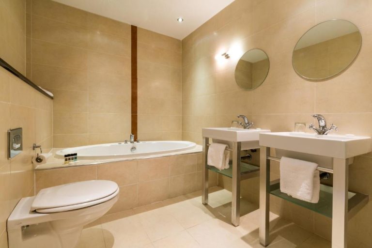 Baño de suite con bañera encastrada y doble lavabo en el Athlone Springs Hotel