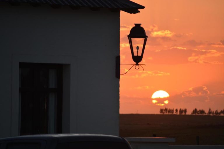 Atardecer dorado visto desde la fachada exterior del Hotel Santa Cristina con farola vintage