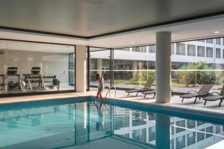 Piscina interior climatizada con gimnasio y tumbonas del Azoris Royal Garden Hotel en las Azores