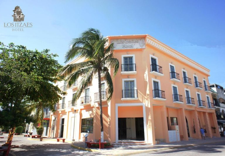 Fachada exterior del Hotel Los Itzaes by 5th Av en Playa del Carmen con palmeras y arquitectura colonial