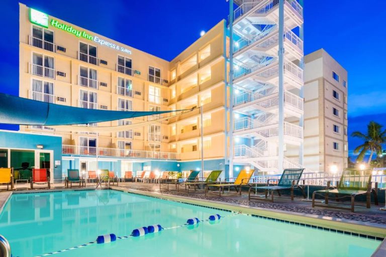 Piscina exterior iluminada con tumbonas del Holiday Inn Express & Suites Nassau by IHG al atardecer