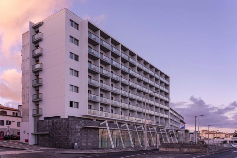 Fachada exterior del Hotel Marina Atlântico con balcones y vista al puerto al atardecer