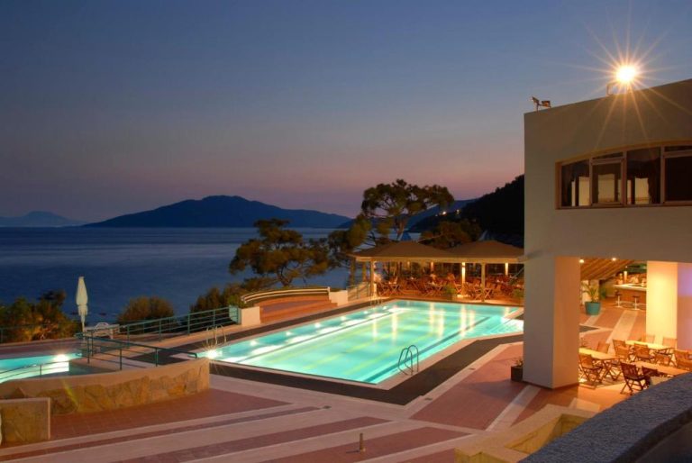 Piscina exterior iluminada al atardecer con vistas al mar en Hapimag Sea Garden Resort