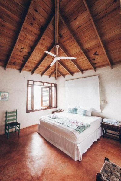 Habitación doble con techo de madera a dos aguas y ventilador de techo en Altos de Caño Hondo