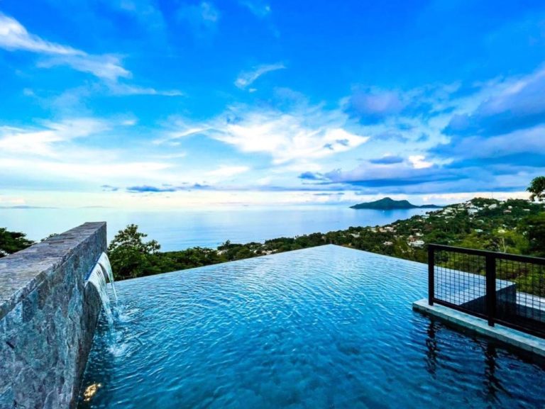 Piscina infinita con vistas al océano y vegetación tropical en AQUA Boutique Hotel, suites exclusivas con vista al mar