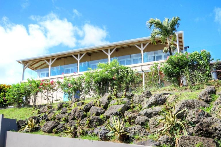 Fachada exterior de The Bahi Villa Adults Only con terraza acristalada y jardín tropical sobre rocas volcánicas