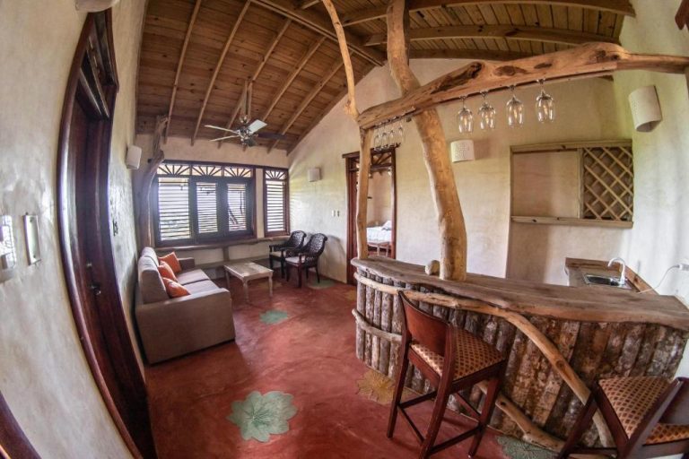 Suite rústica con barra de bar en madera natural y sala de estar en Paraíso Caño Hondo