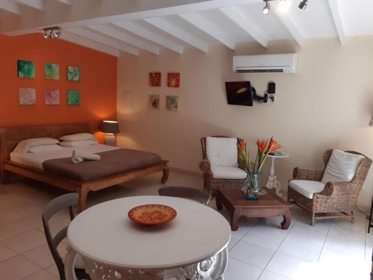 Suite junior con cama doble, zona de estar y decoración tropical en Wonders Boutique Hotel
