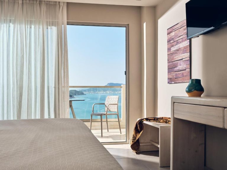 Habitación con balcón y vistas al mar turquesa en el Ionian Hill Hotel