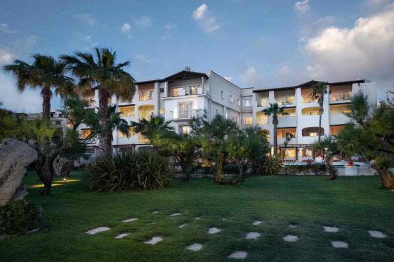 Jardines exteriores con palmeras y césped del Hotel Villa Margherita al atardecer
