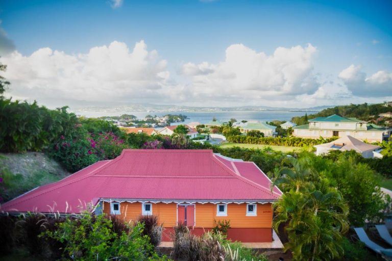 Vista aérea de La Suite Villa con tejado rojo y vistas al mar y la bahía en Martinica