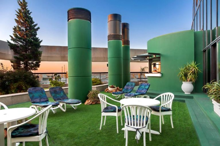 Terraza exterior con sillas y mesas blancas en la azotea del Radisson Montevideo Victoria Plaza Hotel