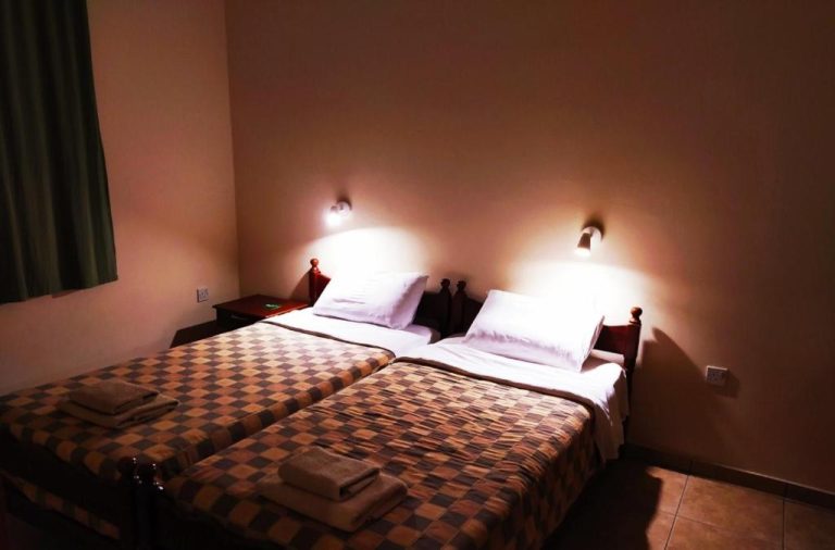 Habitación doble con dos camas y colcha a cuadros en Sea N Lake View Hotel Apartments