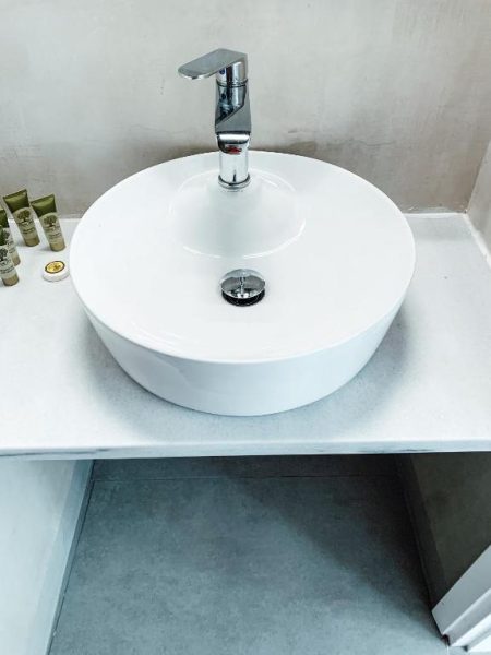 Lavabo redondo de diseño moderno con grifo cromado en el baño de Fabrica Sunset Apartments