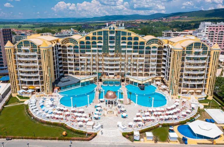 Vista aérea de la piscina exterior con tumbonas y sombrillas del Imperial Palace Hotel
