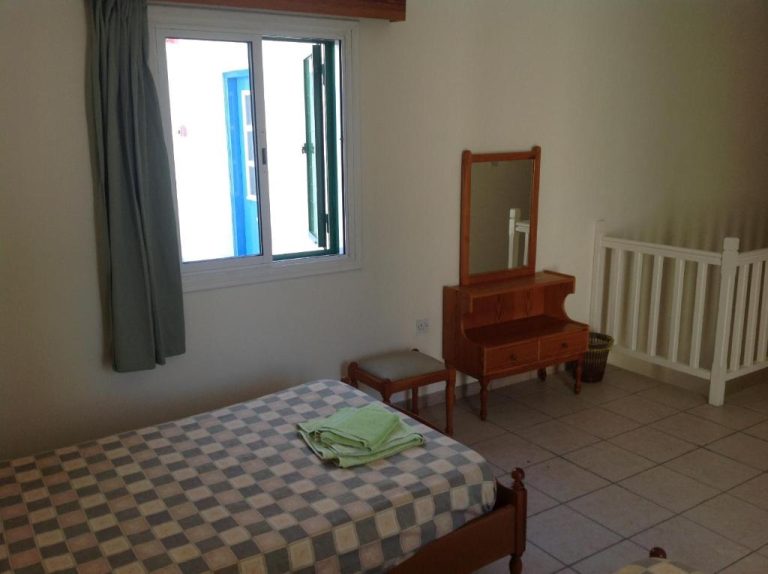 Habitación individual con cama, tocador de madera y espejo en Sea N Lake View Hotel Apartments