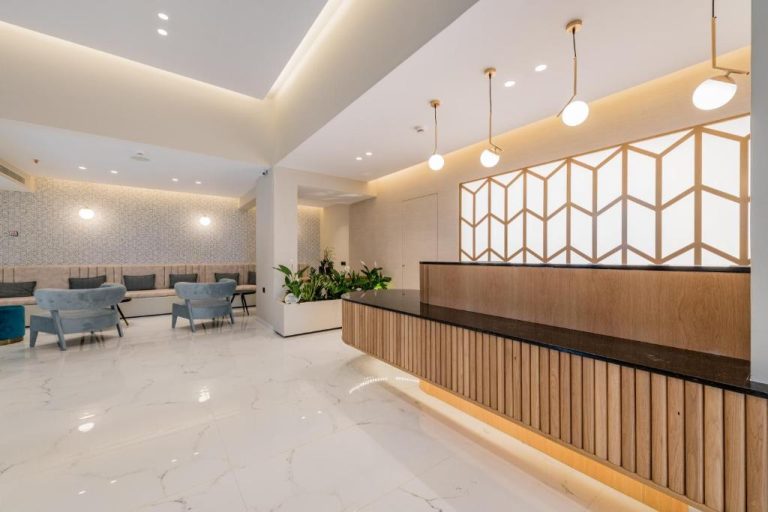 Recepción moderna con mostrador de madera y zona de descanso en Katerina Palace Hotel