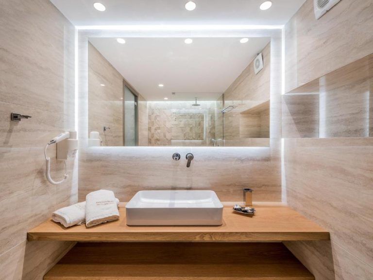 Baño moderno con lavabo de porcelana y espejo retroiluminado en Katerina Palace Hotel