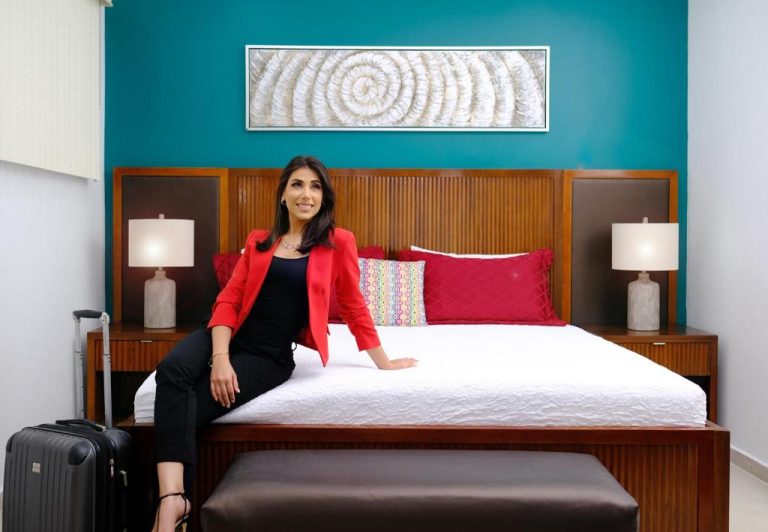 Habitación doble del Victoria City Hotel con cama king size, cabecero de madera y pared turquesa