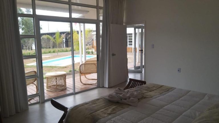 Habitación con cama doble y acceso directo a la piscina exterior en Hotel Terrazas del Río Negro