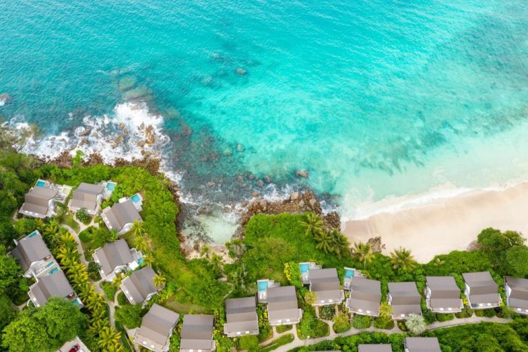 Vista aérea de las villas del Hotel Carana Beach rodeadas de vegetación tropical frente al mar turquesa de Seychelles