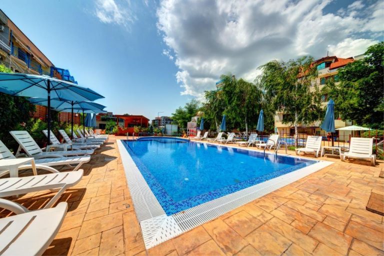 Piscina exterior con tumbonas y sombrillas azules del Hotel Paloma en el centro de la ciudad